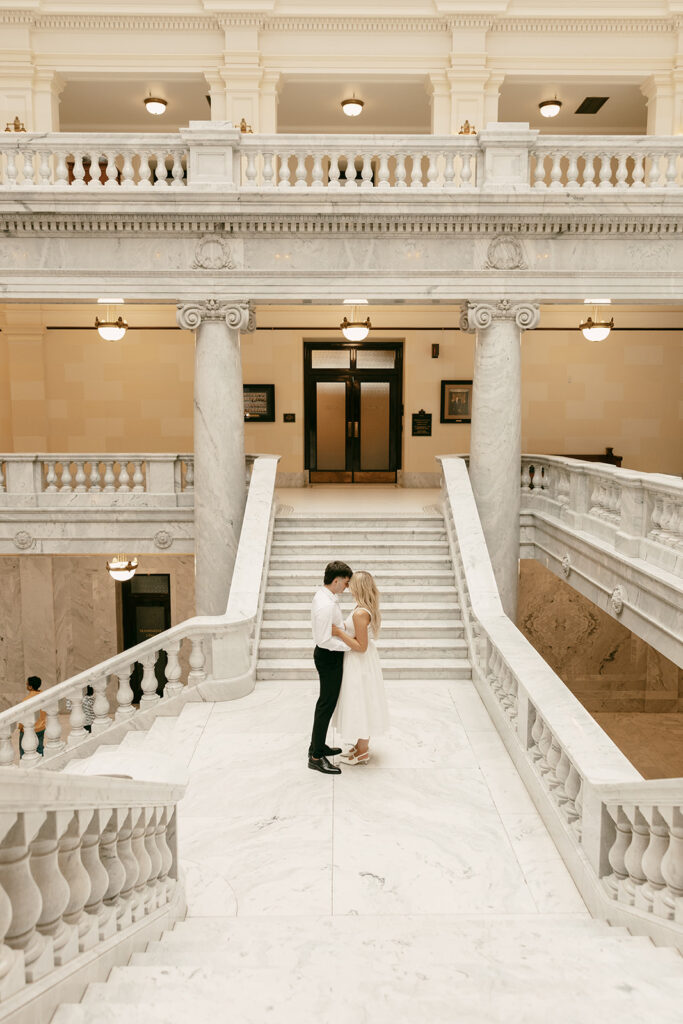 Romantic moment shared at the bottom of grand marble staircase