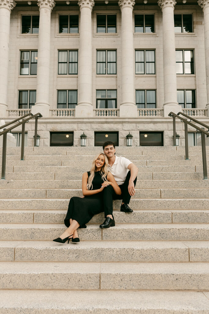 Couple seated on Capitol steps, smiling and leaning into one another