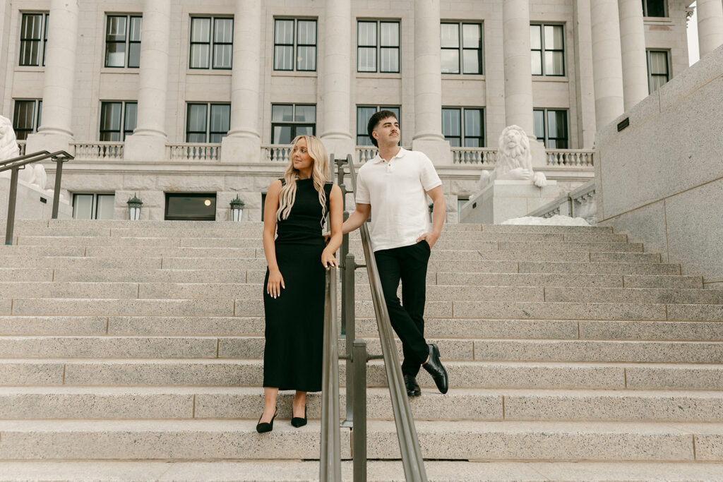 Couple standing apart on grand Capitol staircase, gazing into the distance
