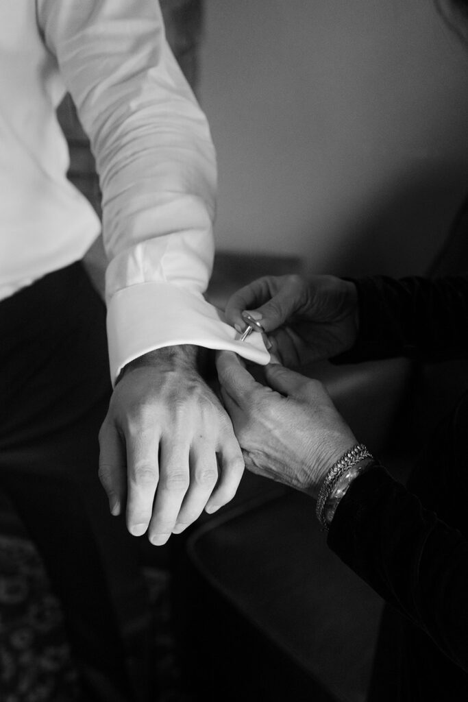 Groom's cufflinks are secured during getting ready moments before the ceremony
