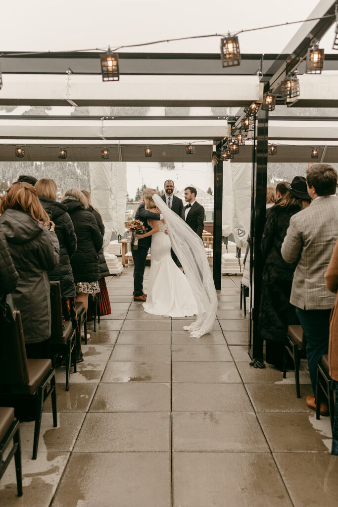 Bride walks the aisle on The Cloudveil’s rooftop with mountain views and loving guests