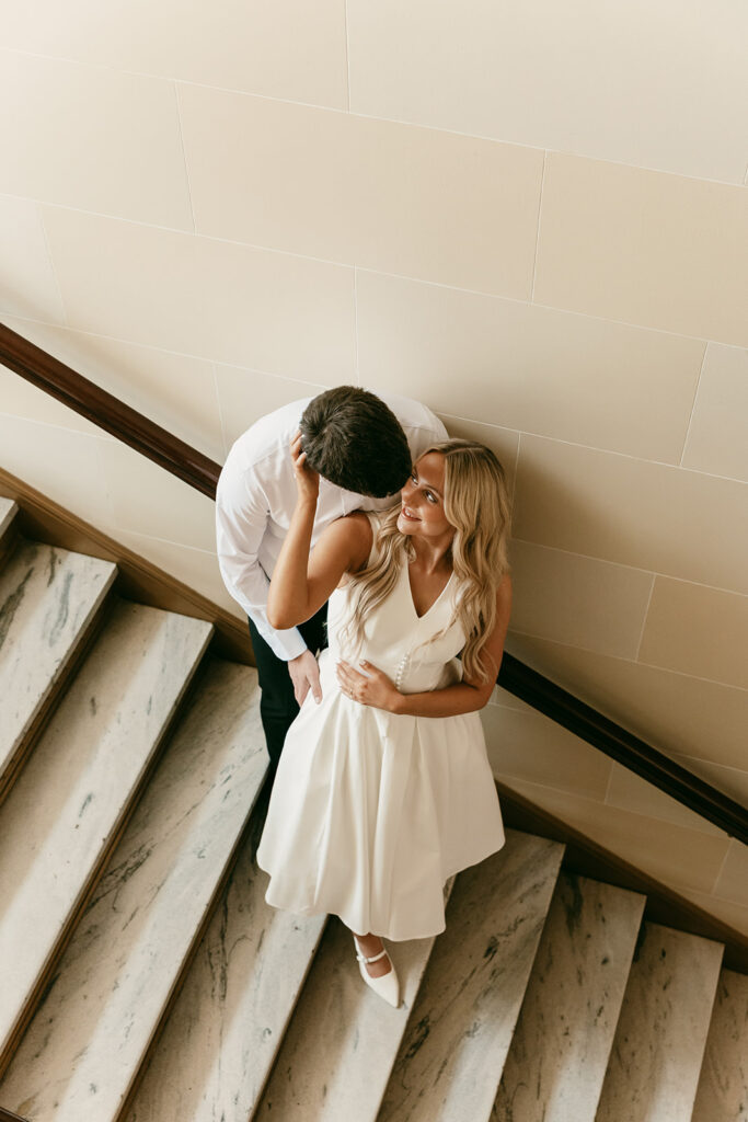 Romantic overhead shot of couple cuddled on marble staircase