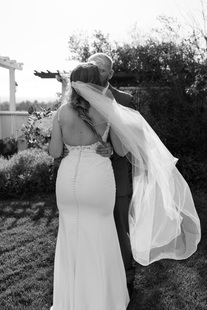 Sonoma County destination wedding bride and groom share a quiet moment as the veil flows in the breeze during their first look.