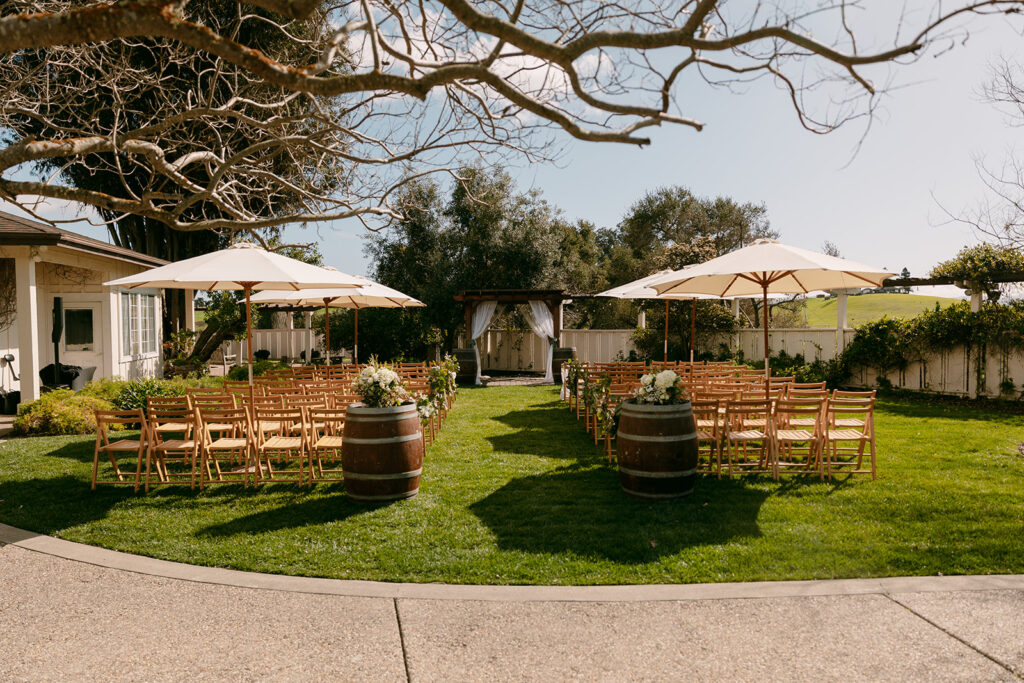 Outdoor wedding ceremony setup at Flying Cloud Farm with wooden chairs and wine barrels.