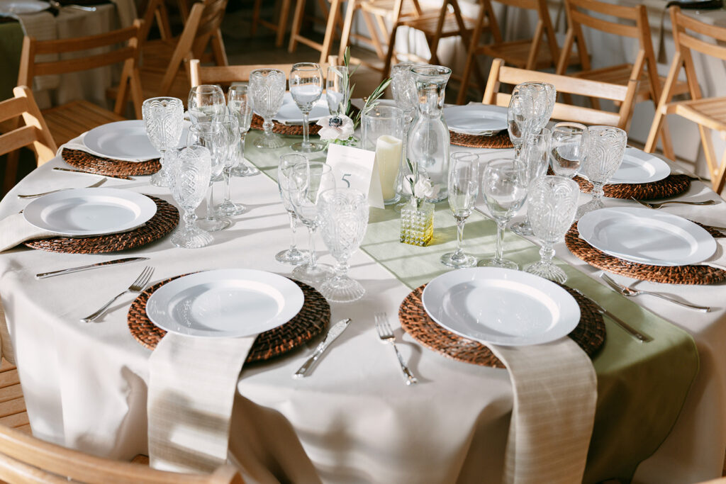 Reception table set with vintage glassware and greenery at Flying Cloud Farm.