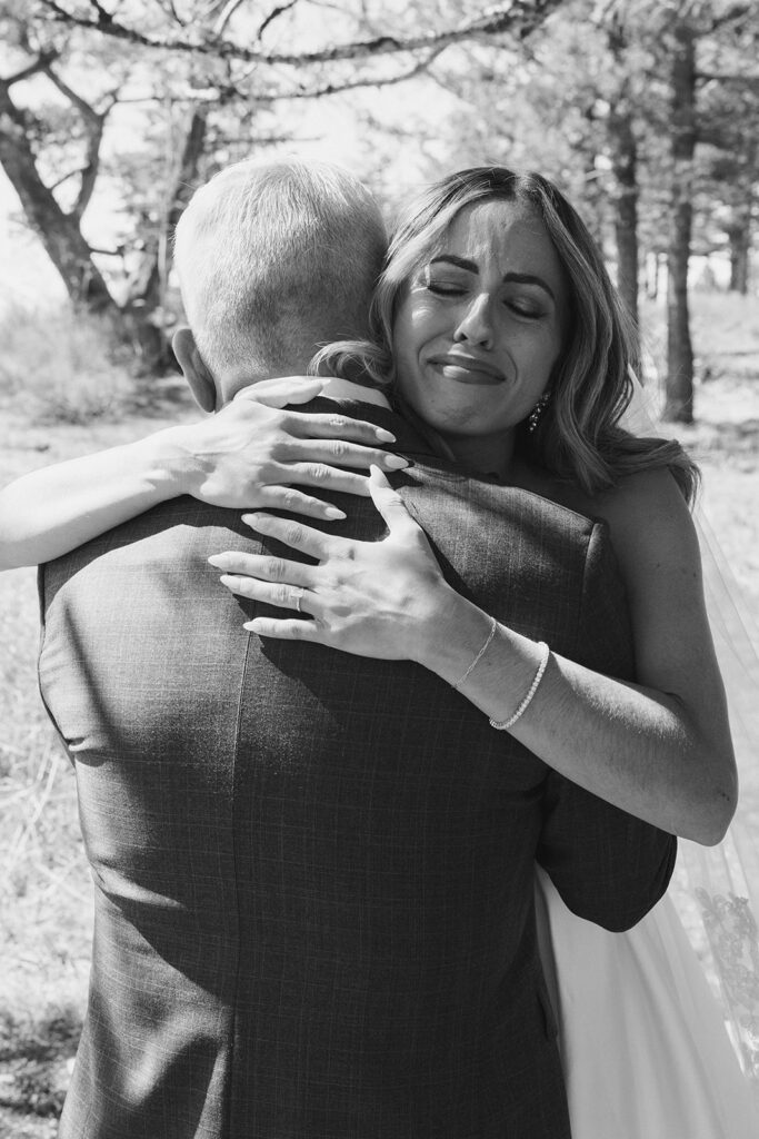 Bride embraces her father in an emotional first look on the wedding day.