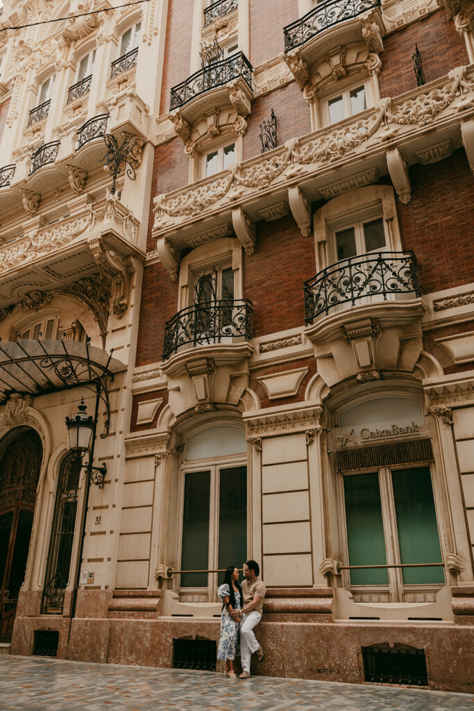 Couple holding hands outside ornate building on a Cartagena street corner