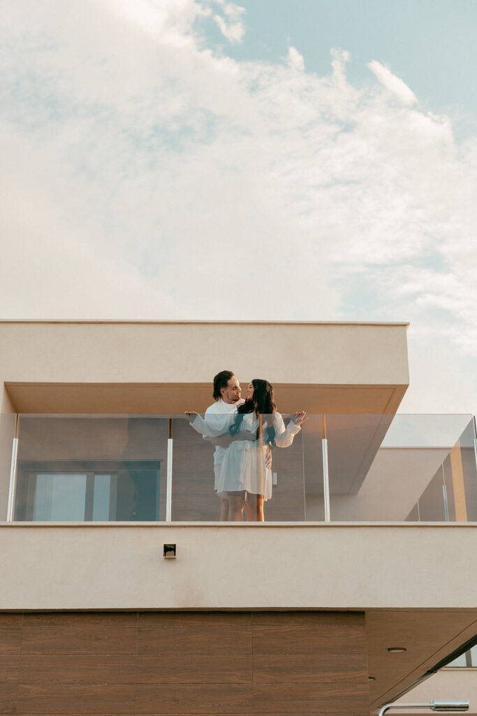 Couple shares morning balcony moment with views before their intimate wedding in Spain