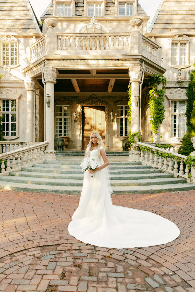 Bride poses in front of La Caille’s grand entrance for La Caille bridal portraits