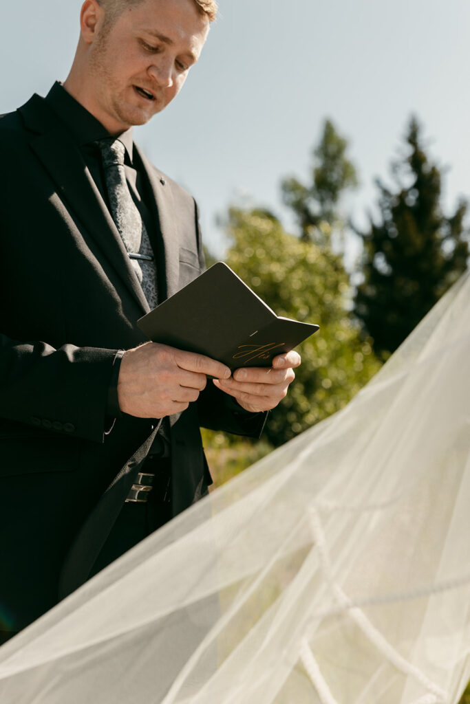 Groom hold his vow book during Grand Teton vow exchange