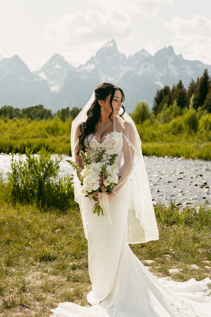 Bride poses with her all white bouquet in Grand Teton National Park