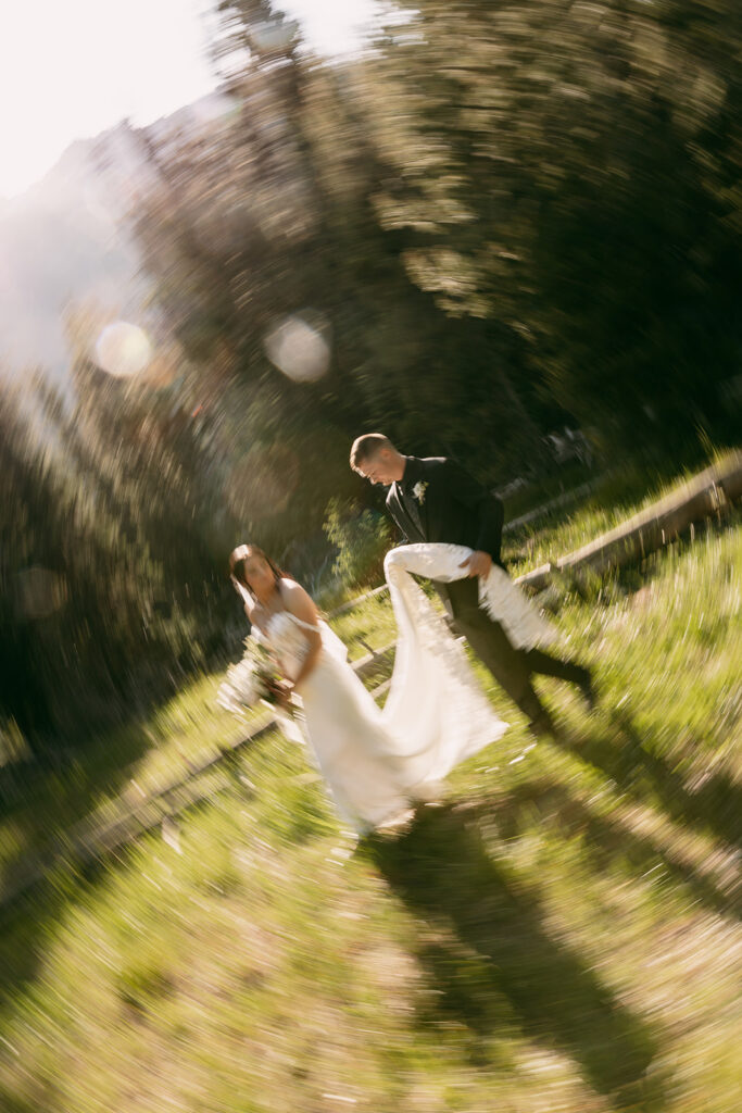 Artistic blur over groom carrying bride's train at Schwabacher Landing