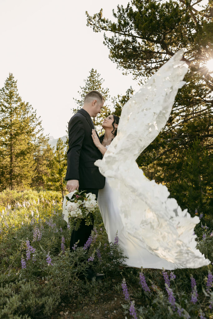 Bride and groom share an intimate moment as her dress blows in the wind