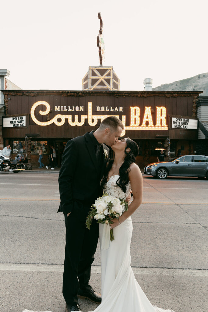 Bride and groom kiss in front of Jackson Hole's Cowboy Bar
