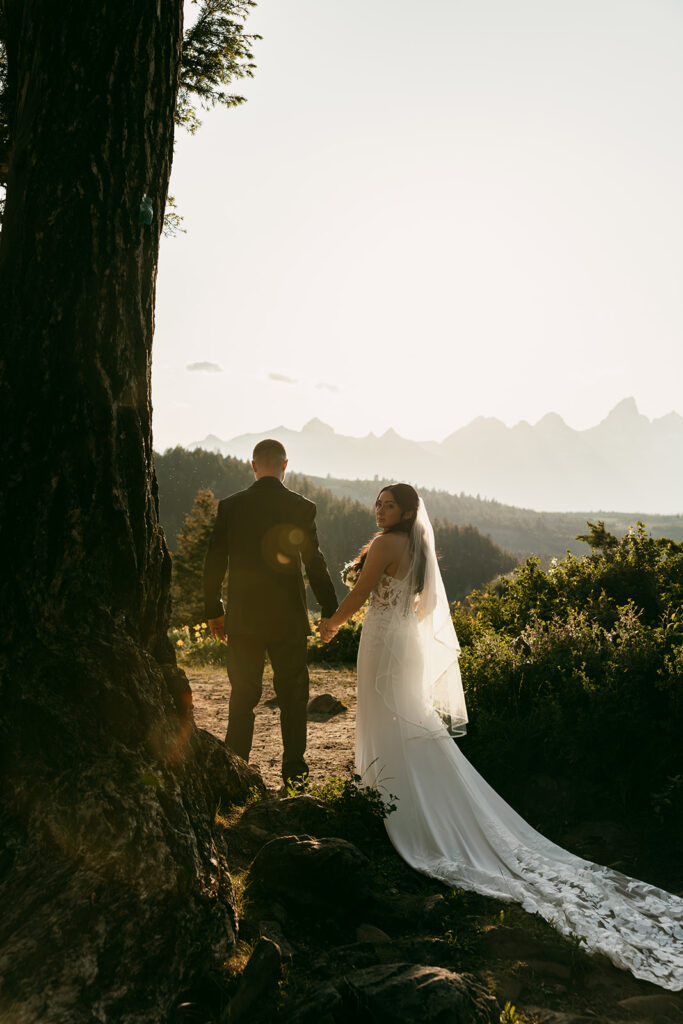 Groom holds the bride close as they take in the quiet beauty of Grand Teton National Park