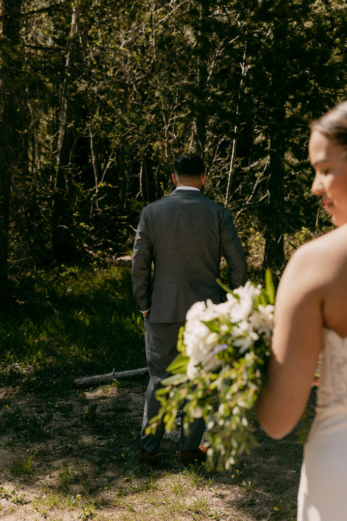 Groom waiting for his bride during summer elopement in the Tetons first look