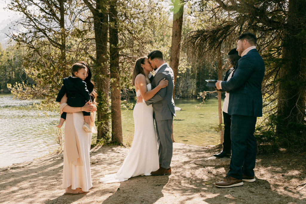 Bride and groom share first kiss during summer elopement in the Tetons