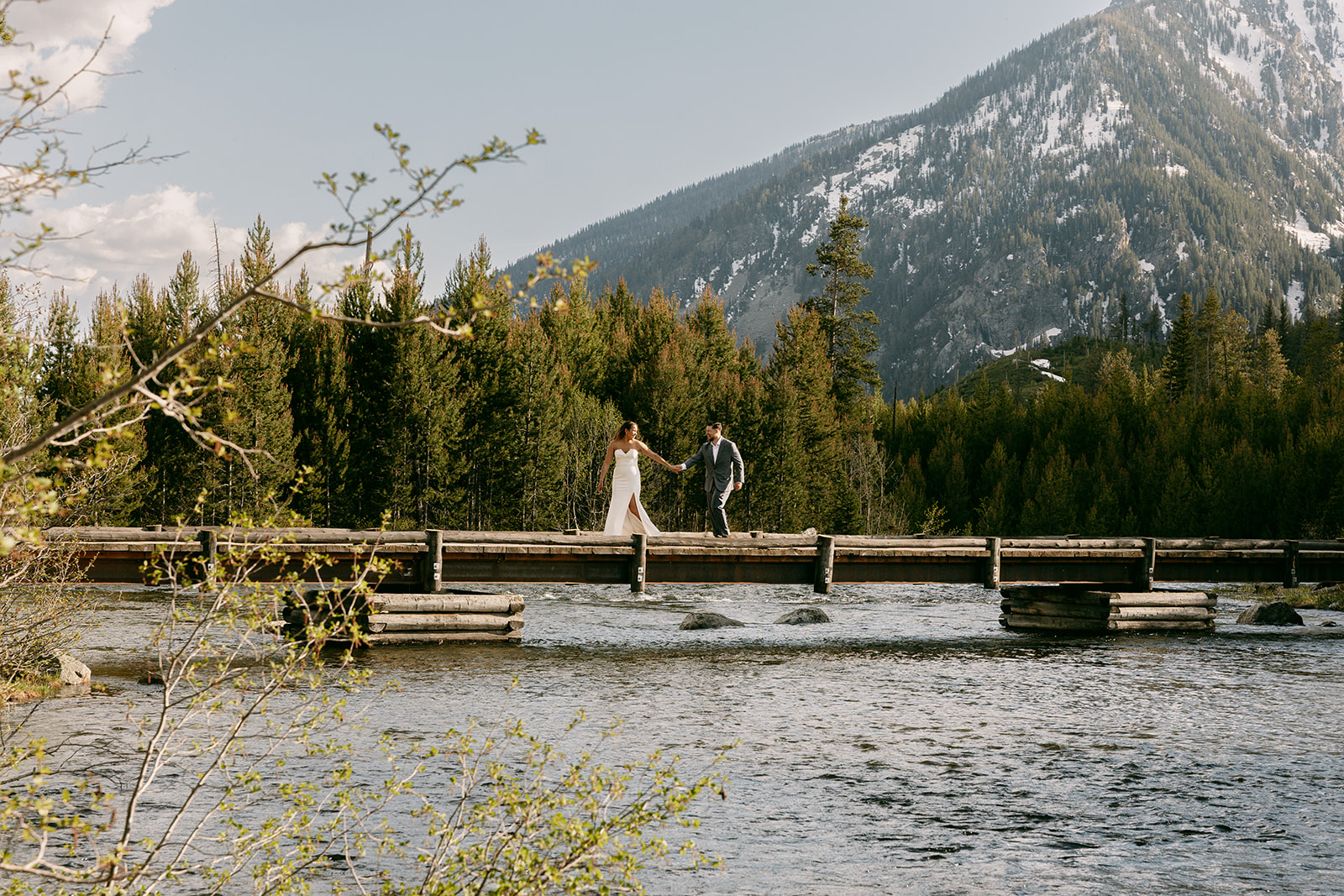 Bride and groom cross String Lake bridge hand in hand