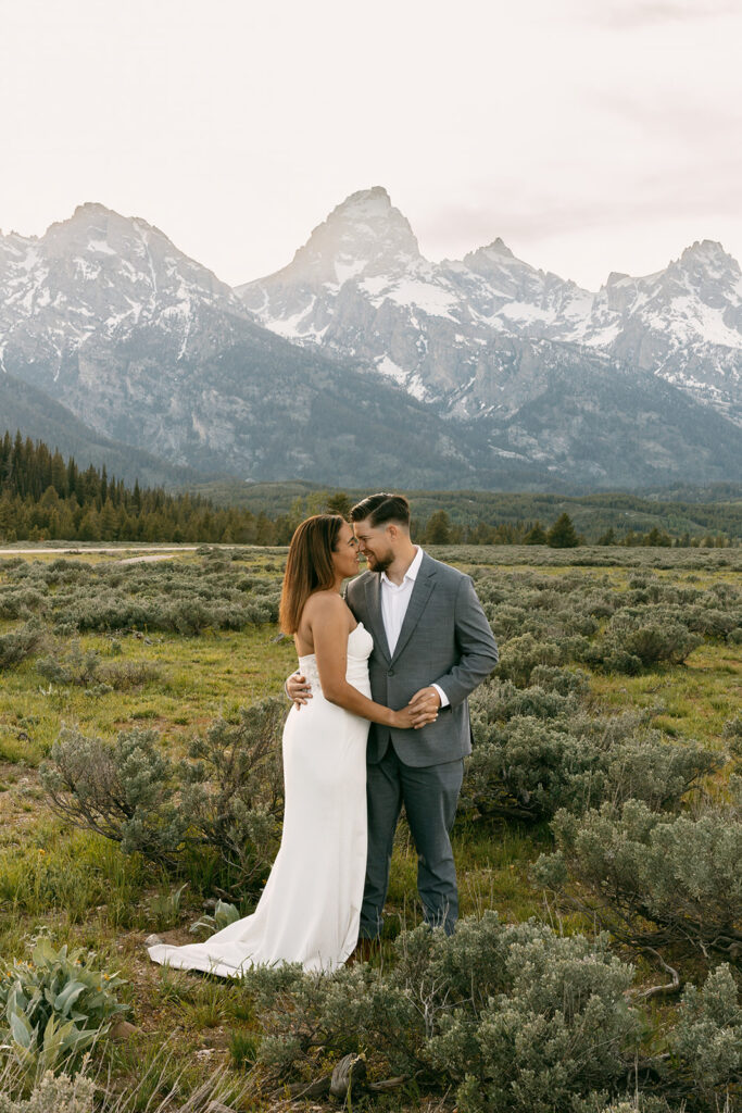 Bride and groom dance in a meadow at the foot of the Grand Teton mountains