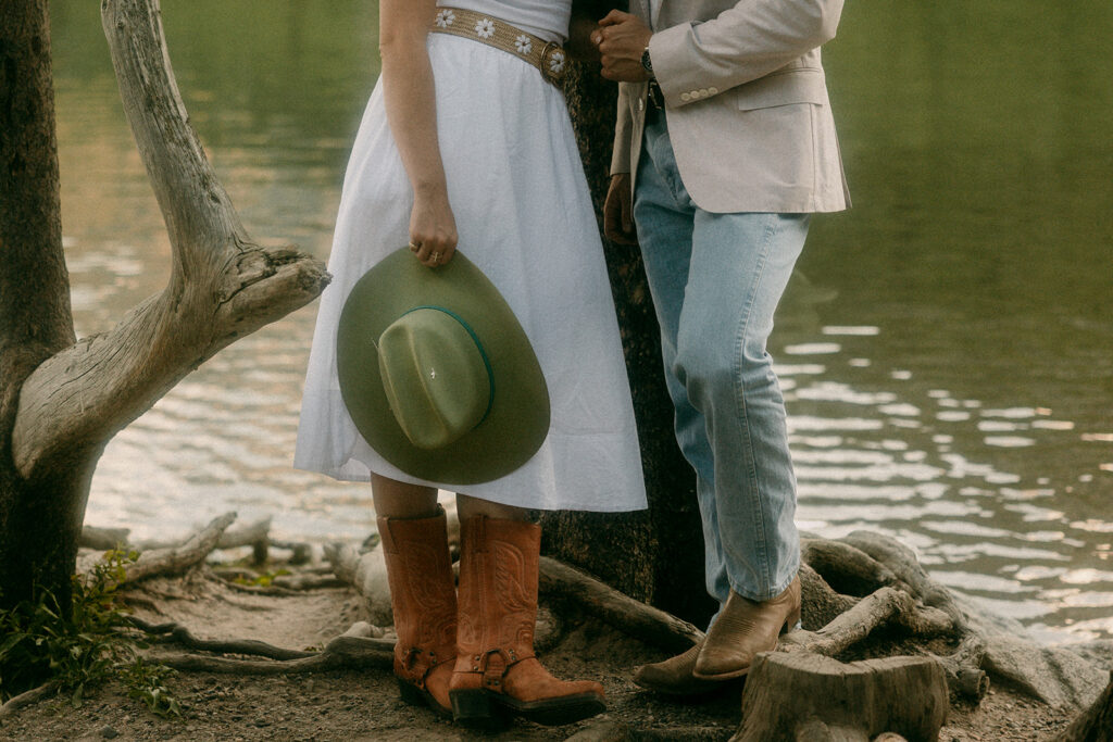 Man and woman holding western hat standing beside String Lake