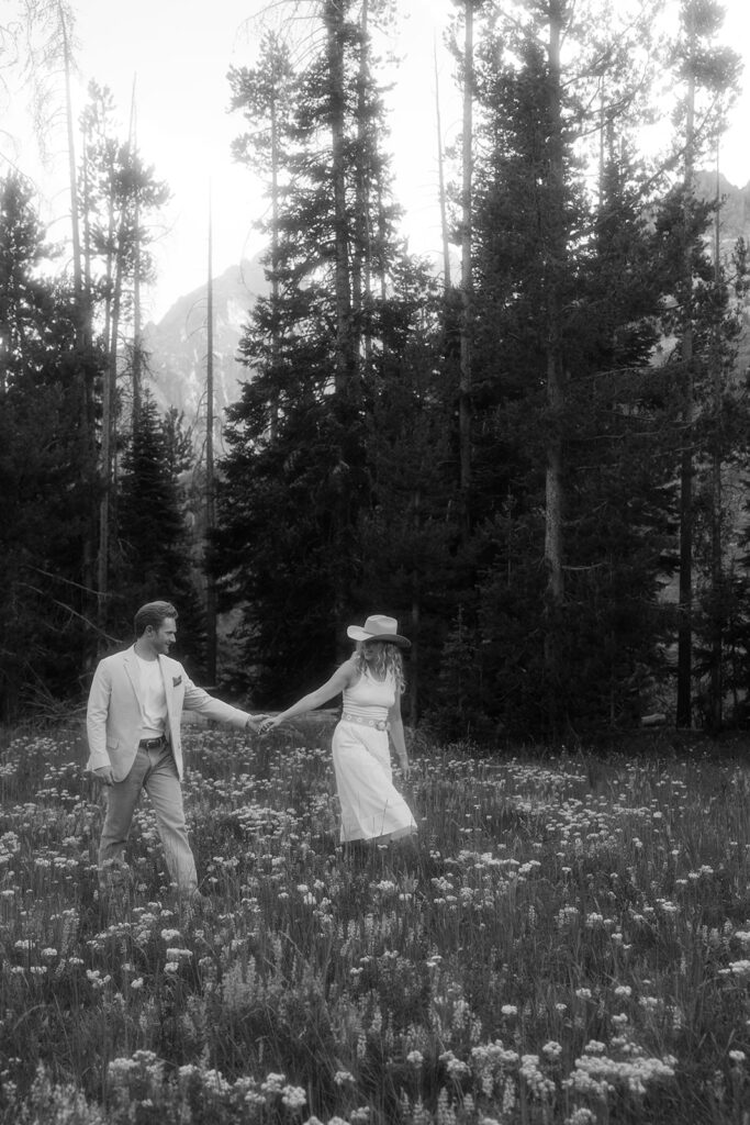 Black and white engaged couple holding hands while exploring Grand Teton National Park