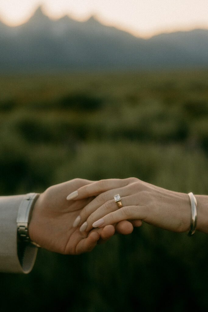 Engaged couple holding hands during romantic Tetons engagement photography shoot