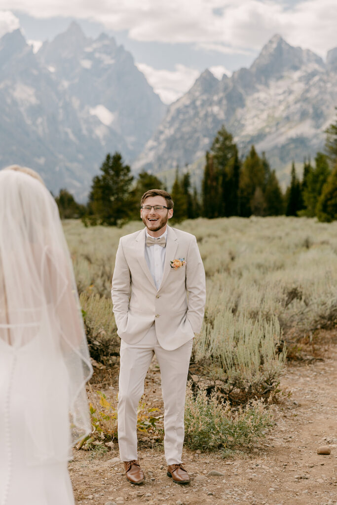 Groom smiling and looking amazed during Jackson Hole wedding first look