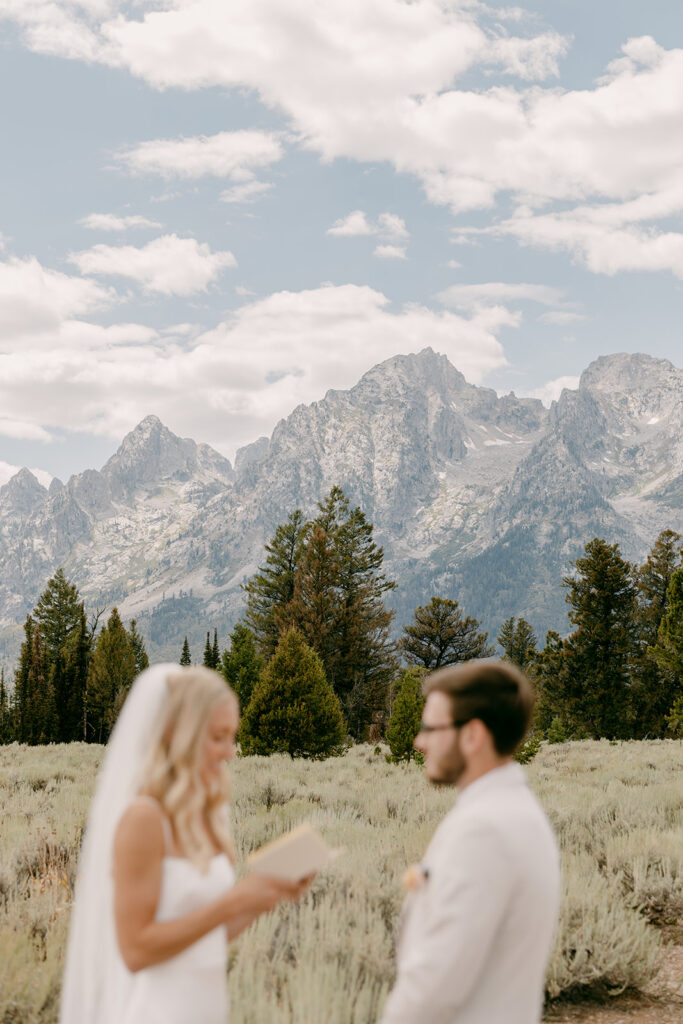 Bride and groom exchange private vows with Grand Teton mountains behind them