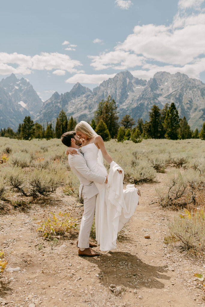 Groom lifts bride during wyoming adventure wedding portraits