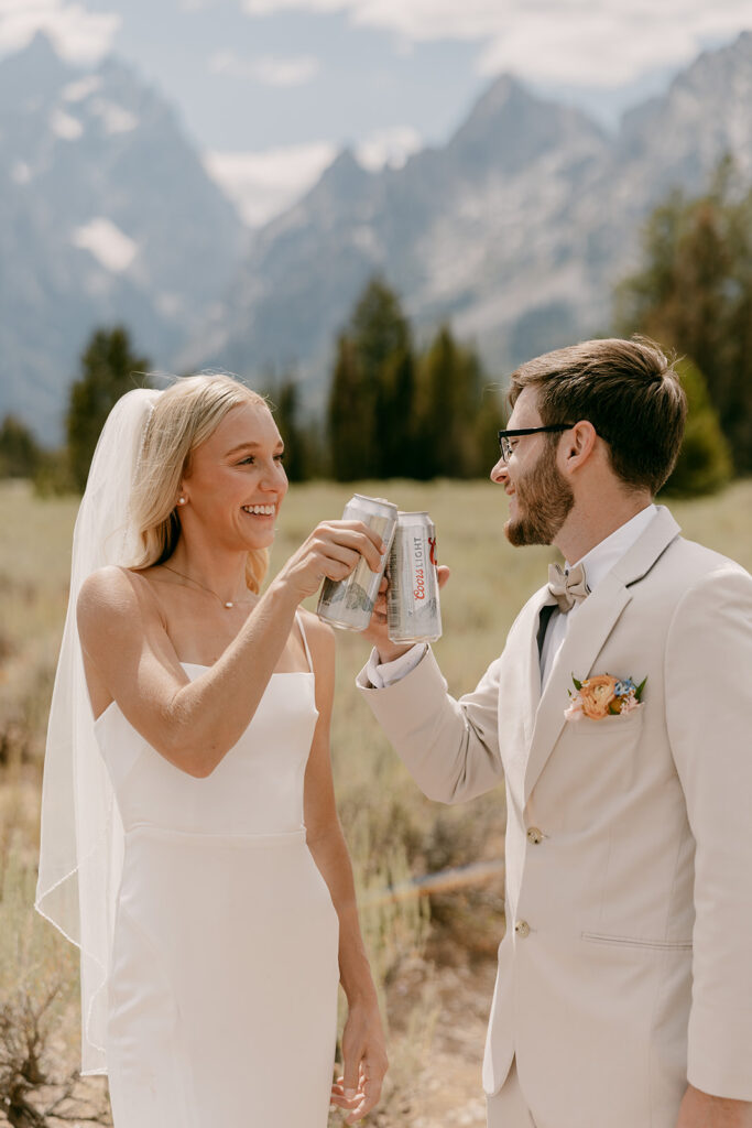Bride and groom cheersing cans of cold beer before Jackson Lake Lodge wedding