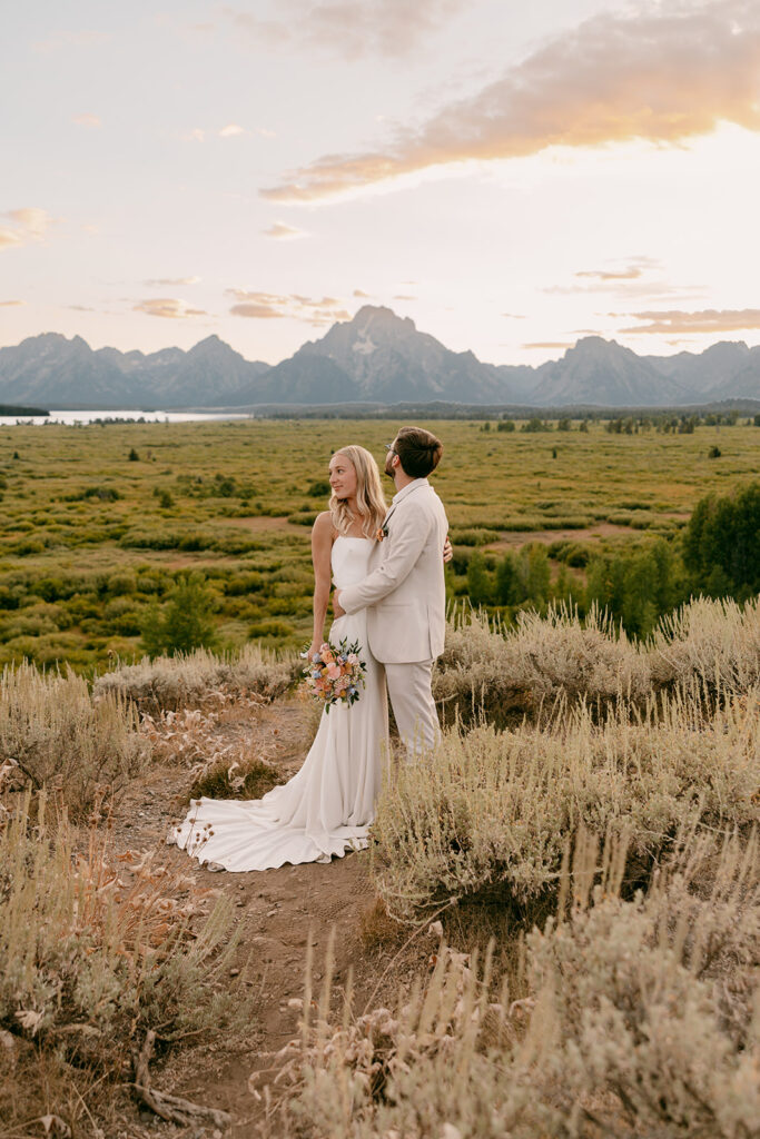 Summer bride and groom pose at sunset in Grand Teton National Park