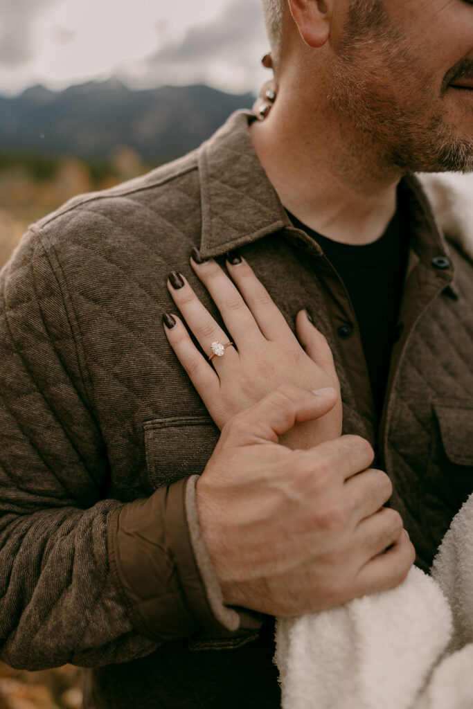 Diamond engagement ring detail on bride’s hand during Grand Tetons engagement photography with fall mountain views.