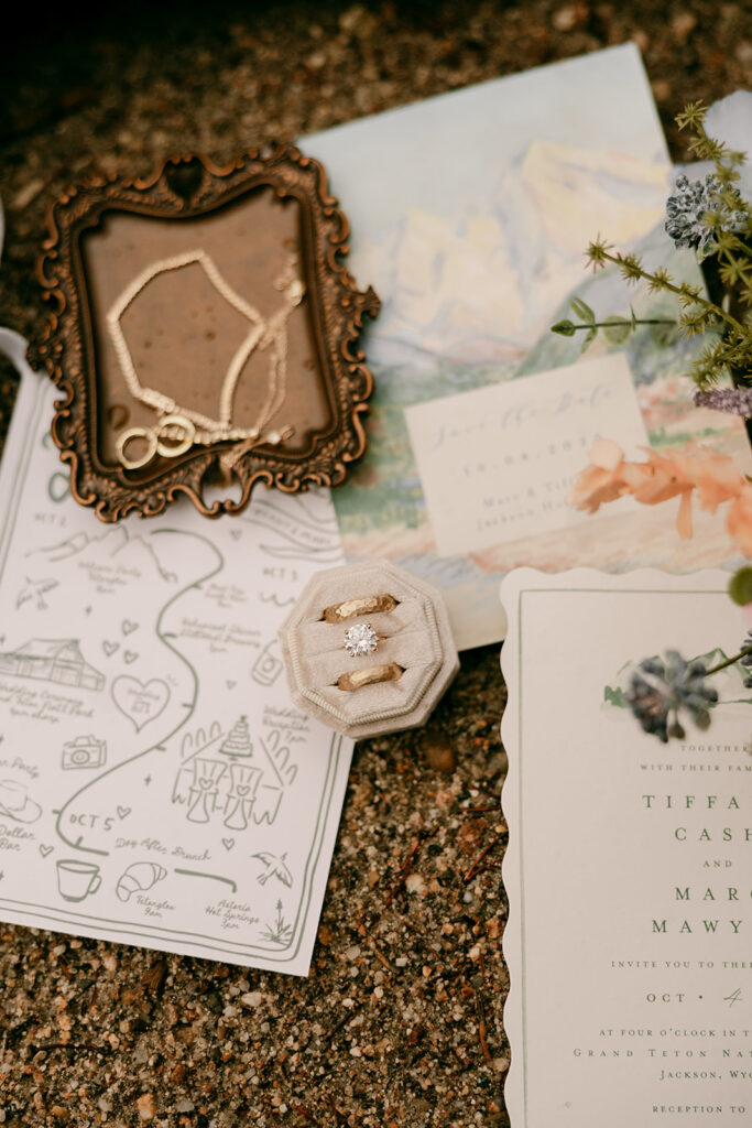 Grand Tetons wedding day flat lay with rings and colorful stationary.