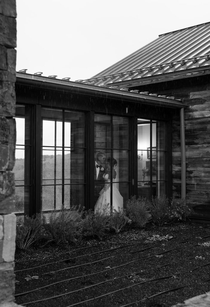 Bride and groom walk inside glass walkway in the Tetonglow at Spring Creek Ranch.