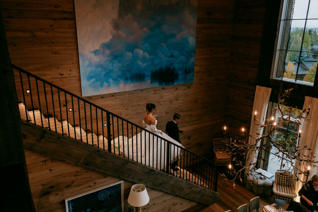 Bride and groom decend staircase to their Tetonglow wedding reception.